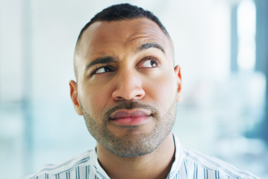 A man with one raised eyebrow, looking sideways with curiosity or skepticism.