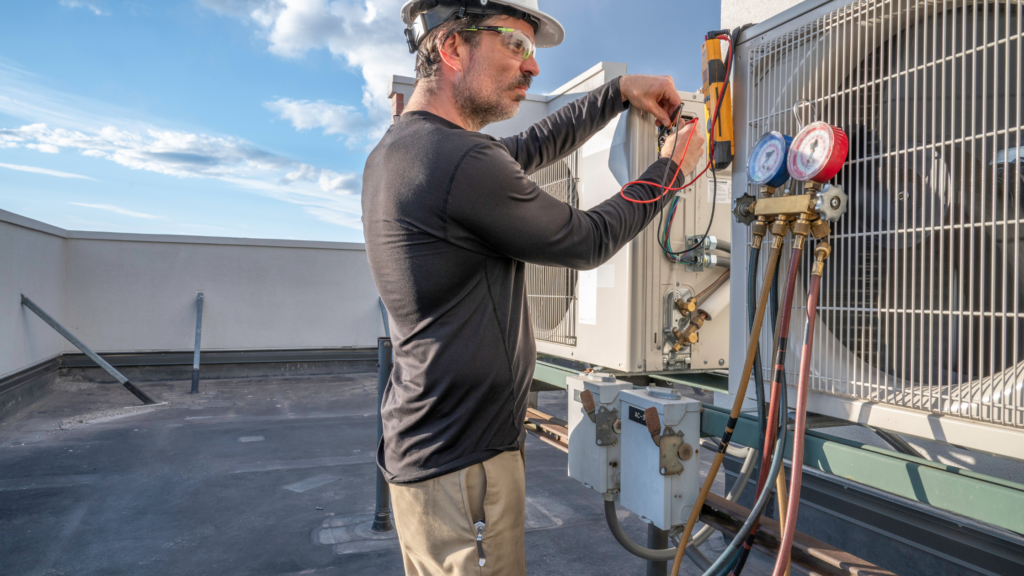 A skilled man wearing protective goggles, fixing HVAC equipment on a rooftop.