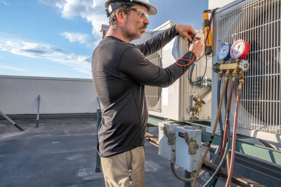 A skilled man wearing protective goggles, fixing HVAC equipment on a rooftop.