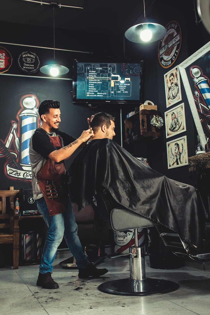 smiling man cutting another mans hair inside shop